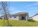 View of the backyard with a covered patio and well maintained green lawn at 191 Bottle Brush Dr, Haines City, FL 33844