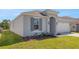 Front exterior featuring a well-kept lawn and attractive light grey stucco at 191 Bottle Brush Dr, Haines City, FL 33844
