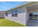 Rear exterior view of the house, highlighting the patio and sliding glass doors at 191 Bottle Brush Dr, Haines City, FL 33844