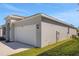 Side view of house with a large two-car garage and manicured lawn at 191 Bottle Brush Dr, Haines City, FL 33844