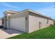 Side view of a well-maintained home featuring an attached two-car garage and lush green lawn at 191 Bottle Brush Dr, Haines City, FL 33844