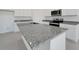Bright kitchen features white cabinets, stainless steel appliances, and speckled granite countertops at 191 Bottle Brush Dr, Haines City, FL 33844