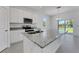 Bright kitchen featuring white cabinets, granite countertops, stainless appliances, and a large center island at 191 Bottle Brush Dr, Haines City, FL 33844