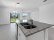 Bright kitchen with a granite countertop island, stainless steel sink, and sliding glass door at 191 Bottle Brush Dr, Haines City, FL 33844