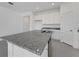 Kitchen featuring a large island with granite countertops, a sink, and white cabinets at 191 Bottle Brush Dr, Haines City, FL 33844