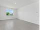 A brightly lit Living Room is presented with gray floor tiles and a large window at 191 Bottle Brush Dr, Haines City, FL 33844