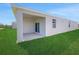 Rear of home with a covered lanai and sliding glass doors to the backyard at 191 Bottle Brush Dr, Haines City, FL 33844