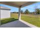 Covered patio with view of the expansive green lawn at 191 Bottle Brush Dr, Haines City, FL 33844