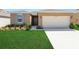 Charming single-story home with a well-manicured lawn and attached two-car garage at 207 Bottle Brush Dr, Haines City, FL 33844