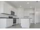 Spacious kitchen with white cabinetry, stainless steel appliances, and a granite countertop island at 207 Bottle Brush Dr, Haines City, FL 33844