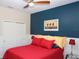 Bedroom with red bedding and a navy blue accent wall at 2360 Park Forest Blvd, Mount Dora, FL 32757