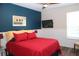 Bedroom with red bedding and a navy blue accent wall at 2360 Park Forest Blvd, Mount Dora, FL 32757