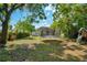 Wide backyard view including a shed, swing set, and trampoline, set among mature landscaping and trees at 622 N Disston Ave, Tavares, FL 32778