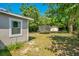 Green backyard featuring a trampoline, lush trees, and a shed providing ample outdoor space for recreation at 622 N Disston Ave, Tavares, FL 32778