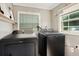 Practical laundry room with black washer and dryer, plus natural light from a window at 622 N Disston Ave, Tavares, FL 32778