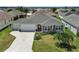 Aerial view of a well-maintained single-story home with manicured lawn, landscaping, and a two-car garage at 736 Jones Ln, The Villages, FL 32163