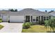 House exterior showcasing a two-car garage and nicely landscaped front yard at 736 Jones Ln, The Villages, FL 32163