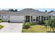 Charming single-story home with a well-maintained front yard and a two-car garage at 736 Jones Ln, The Villages, FL 32163