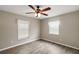 Bedroom with ceiling fan and wood-look laminate floors at 11712 Layton St, Leesburg, FL 34788