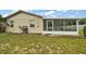 Tan house exterior with screened porch and grassy backyard at 11712 Layton St, Leesburg, FL 34788