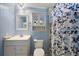 Cozy bathroom featuring stylish blue bead-board walls, a single sink vanity and a toilet at 1605 W Schwartz Blvd, The Villages, FL 32159