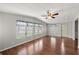 Bright living room featuring wood floors, a ceiling fan, and multiple windows with decorative valances at 1605 W Schwartz Blvd, The Villages, FL 32159
