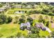 Aerial view of two houses, golf course, and pond in a residential community at 557 Dowling Cir, Lady Lake, FL 32159