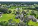 Aerial view of luxurious home situated on a sprawling, manicured lot in a golf course community at 557 Dowling Cir, Lady Lake, FL 32159
