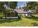 Expansive backyard with lush lawn, screened lanai, and beautiful landscaping at 557 Dowling Cir, Lady Lake, FL 32159