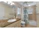 Bathroom vanity with granite countertop, bathtub with shower and decorative shower curtain at 557 Dowling Cir, Lady Lake, FL 32159