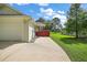 Exterior view of home showing long driveway and lush, green landscaping at 557 Dowling Cir, Lady Lake, FL 32159