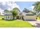 Single-story home with light paint, gray roof, and landscaped lawn at 557 Dowling Cir, Lady Lake, FL 32159