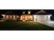 Beautiful home exterior at night with well-manicured lawn at 557 Dowling Cir, Lady Lake, FL 32159