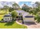 Charming single-story home featuring a well-manicured front lawn, mature trees, and an attached two-car garage at 557 Dowling Cir, Lady Lake, FL 32159