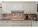 A well-lit kitchen features granite countertops, a white range hood, and ample cabinetry for storage at 557 Dowling Cir, Lady Lake, FL 32159