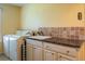 Well-equipped laundry room with granite countertop, sink, cabinets and washer-dryer at 557 Dowling Cir, Lady Lake, FL 32159