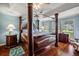 Luxurious main bedroom with four-poster bed, wood floors, and large windows at 557 Dowling Cir, Lady Lake, FL 32159