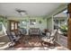 Relaxing covered patio with comfortable seating, ceiling fan, and view of the home's interior at 557 Dowling Cir, Lady Lake, FL 32159