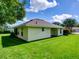 Well-maintained home exterior featuring a lush lawn, screened-in porch, and manicured landscaping at 21945 King Henry Ave, Leesburg, FL 34748