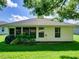 Backyard view of home with lawn, windows, and a covered grill at 21945 King Henry Ave, Leesburg, FL 34748