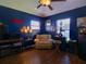 Cozy den with dark blue walls, comfortable armchair, and wood floors at 21945 King Henry Ave, Leesburg, FL 34748