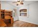 Bedroom showcasing a built-in desk and shelving, hardwood floors, a ceiling fan, and a window for natural light at 5008 Greenbriar Trl, Mount Dora, FL 32757