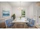 Elegant dining room with a white wood table set for six, chandelier, and serene artwork at 5008 Greenbriar Trl, Mount Dora, FL 32757