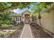 Inviting front entrance with a paver walkway, lush landscaping, and a charming archway over the front door at 5008 Greenbriar Trl, Mount Dora, FL 32757