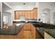 Kitchen featuring wood cabinets, granite countertops, island and view of the entryway at 5008 Greenbriar Trl, Mount Dora, FL 32757