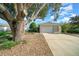 House exterior with a large tree and a gravel driveway at 9215 Sw 90Th St, Ocala, FL 34481