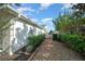 Side yard with gravel pathway, hedges, and a gate at 9215 Sw 90Th St, Ocala, FL 34481