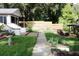 Pathway through backyard leading to a wooden fence and patio area at 4219 Magnolia Ave, Leesburg, FL 34748