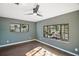 Modern bedroom with dark gray walls, wood floors, and large windows at 4219 Magnolia Ave, Leesburg, FL 34748