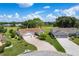 Spacious homes with well-manicured lawns and brick driveways nestled in a golf course community under a bright, cloudy sky at 4830 Summerbridge Cir, Leesburg, FL 34748